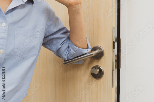 woman using elbow to open the door to avoid covid-19 or coronavirus infection. social distancing and new normal concept photo