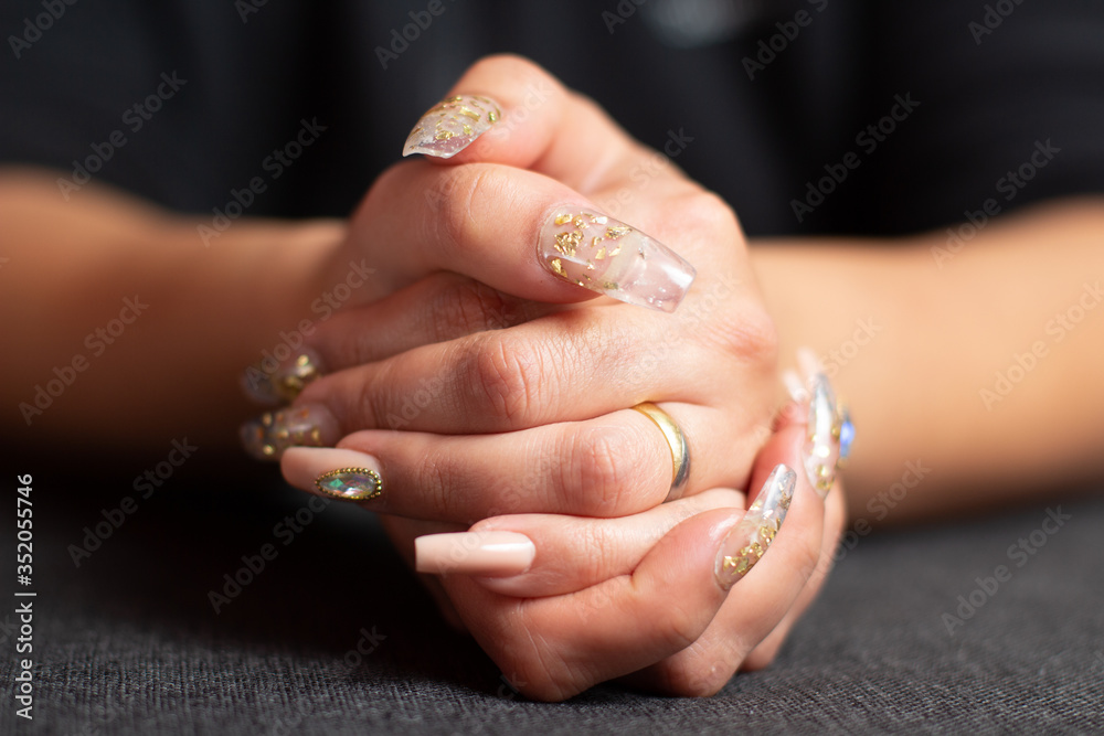 Manicure golden nails with diamonds on a grey background Manicure golden nails with diamonds on a grey background