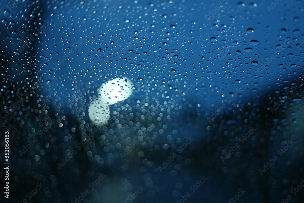 water rain drop on glass window with blur street light in night town ...