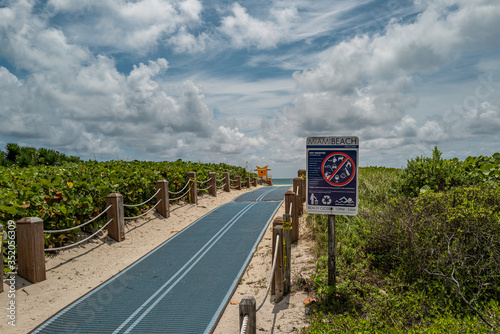 Miami Beach. Beach sign of the rules. Ocean Walkway in Miami Beach. Path to the ocean.