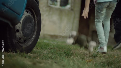 A Kidnapper taking out the child from the ven and taking it into a house. While walking, a girl is dropping the toy from her hands.  Child abduction scene.