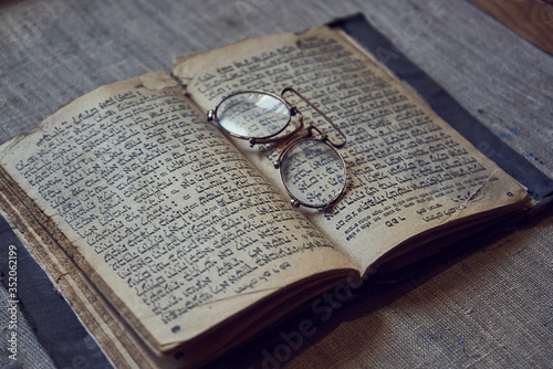 old book and glasses on the table