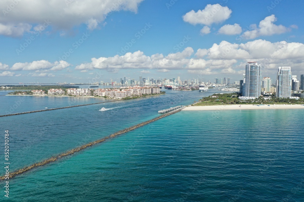 Aerial view of Fisher Island, South Pointe and Government Cut with City of Miami skyline and Port Miami in background.