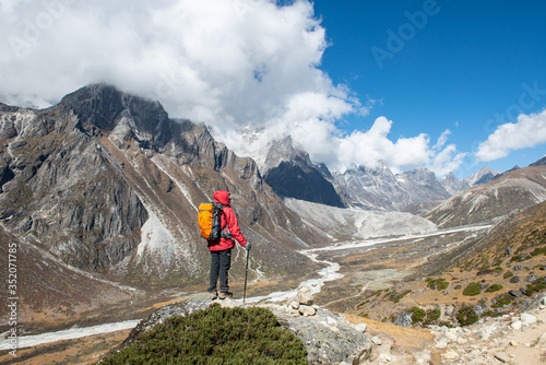 Back view of trekker looking to beautiful view of Himalayas mountain range in Sagarmatha national park, Nepal. Conceptual of tourist trekking in Nepal.