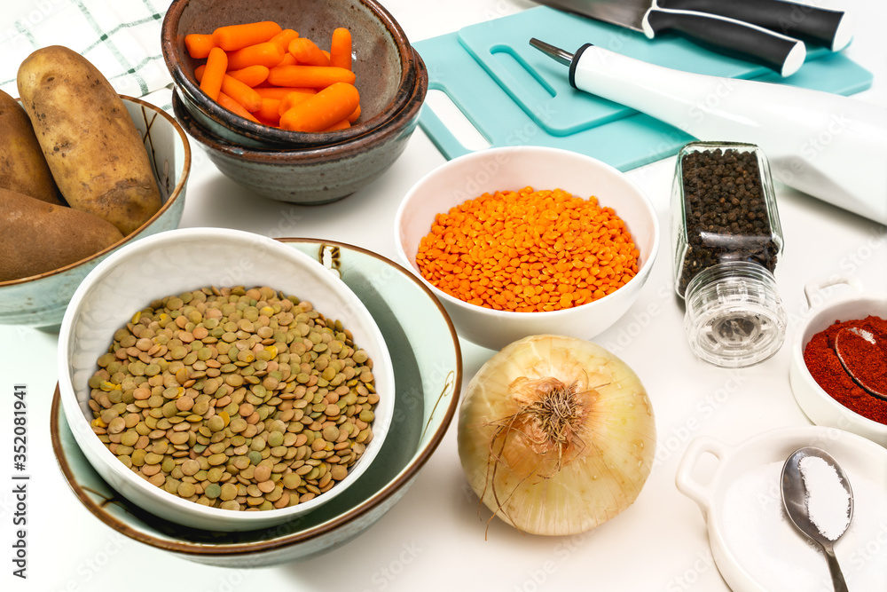 Lentil soup ingredients. Red lentils, green lentils, onion, carrot, potatoes, and some seasoning close up on white background Lentil soup ingredients. Red lentils, green lentils, onion, carrot, potatoes, and some seasoning close up on white background