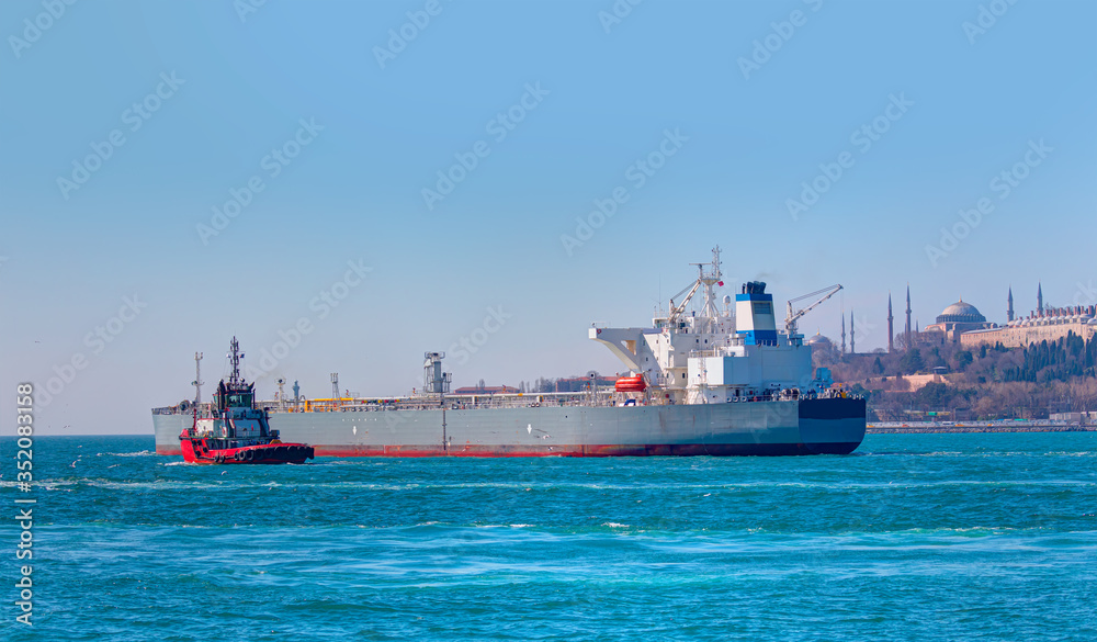 Tugboat assisting cargo ship sea at bosphorus - Famous historical peninsula of Istanbul - Hagia sophia, Sultanahmet Mosque, Topkapi Palace - Istanbul, Turkey