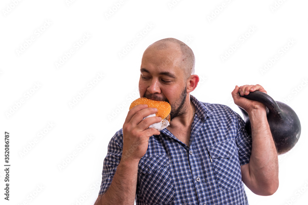 A bearded, fat man with a Burger and a weight in his hands. The concept of a healthy lifestyle A bearded, fat man with a Burger and a weight in his hands. The concept of a healthy lifestyle