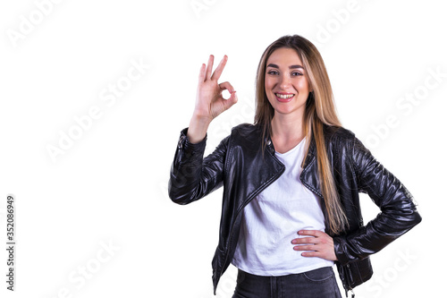 The girl in the leather jacket gestures OK. Isolated on a white background