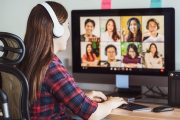 Rear view of Asian woman working and online meeting via video conference with colleague
