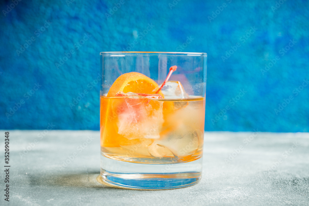 Old fashioned beverage with orange slices on rustic background. Selective focus. Shallow depth of field. Old fashioned beverage with orange slices on rustic background. Selective focus. Shallow depth of field.