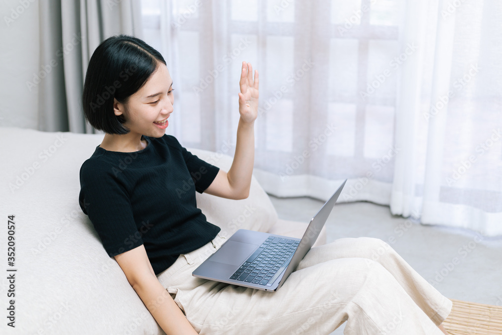 Attractive asian female working with computer laptop at home. Video conferencing call via computer Attractive asian female working with computer laptop at home. Video conferencing call via computer