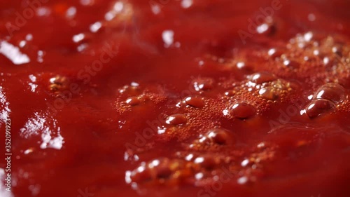 Close-up of boiling red tomato sauce in a pan with steam in 4K Resolution