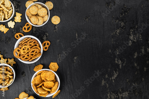Mixed Snacks on dark background (close up shot; selective focus)