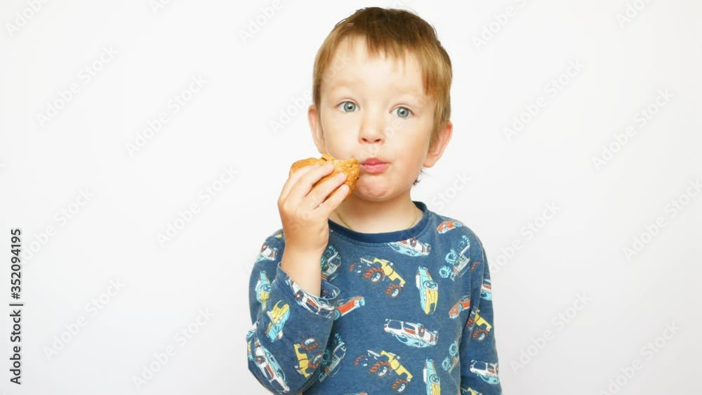 A cute little boy eats a heart shaped cookie A cute little boy eats a heart shaped cookie