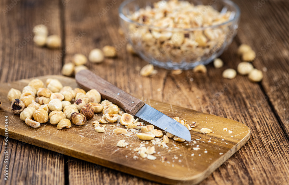 Fototapeta premium Portion of freshly chopped Hazelnuts (close up; selective focus)