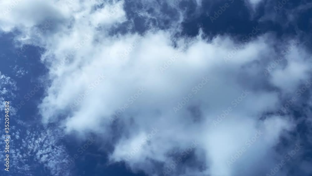 White, low-floating clouds against a blue sky. Fluffy clouds, time lapse shooting, natural background White, low-floating clouds against a blue sky. Fluffy clouds, time lapse shooting, natural background