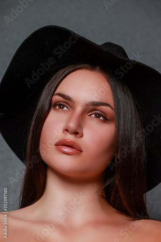 Fotografie Portrait beauté d'une jeune femme brune portant un chapeau