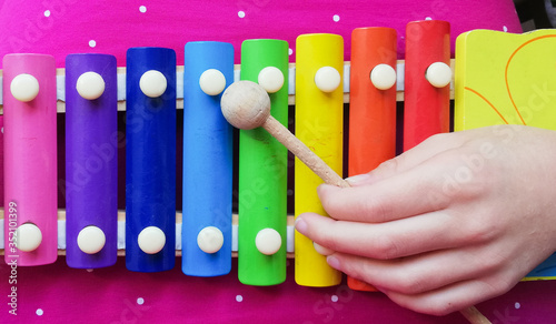 Bild auf Leinwand Child's hand playing colourful xylophone