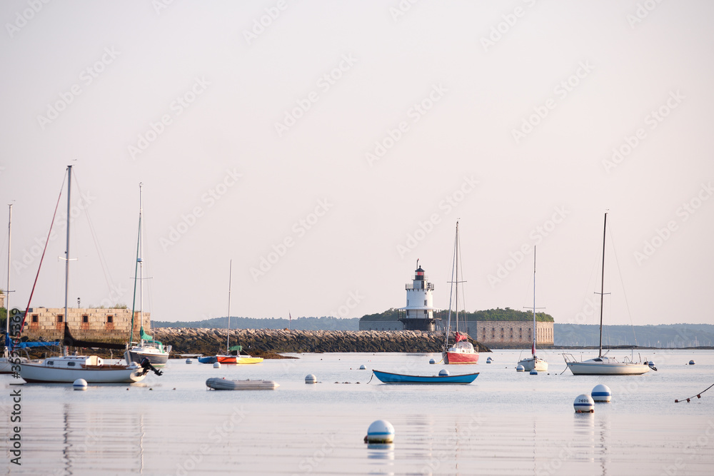 Morning sunrise on the Spring ledge Lighthouse in South Portland Maine overlooking the anchored sail and motor boats