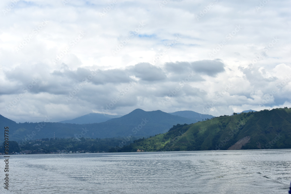 Lake Toba view with blue sky. A large natural lake in Sumatra, Indonesia, occupying the caldera of a supervolcano.
