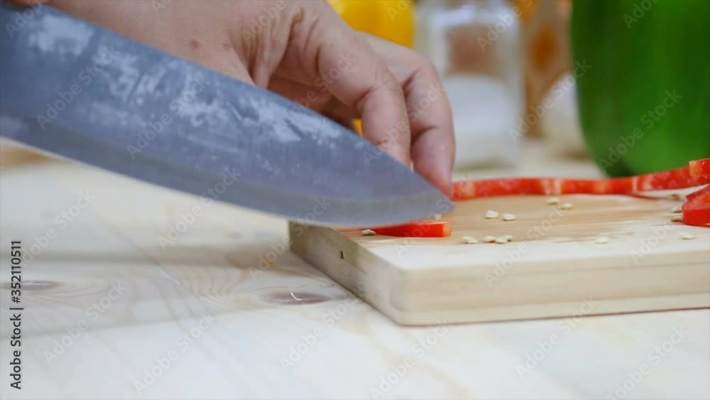 Close up shot Hands of woman using kitchen knife slice and cut the bell pepper vegetable preparing for cooking a food Close up shot Hands of woman using kitchen knife slice and cut the bell pepper vegetable preparing for cooking a food