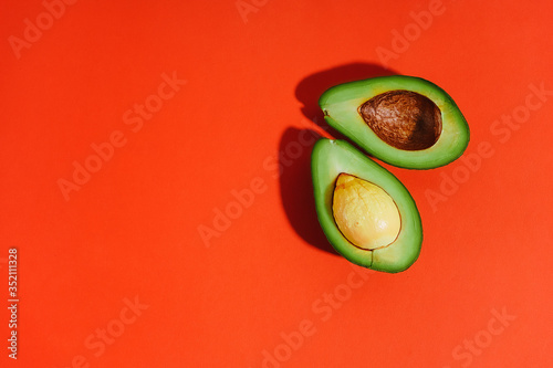Sliced avocado on a red background. Flat lay. Top view. Bright picture