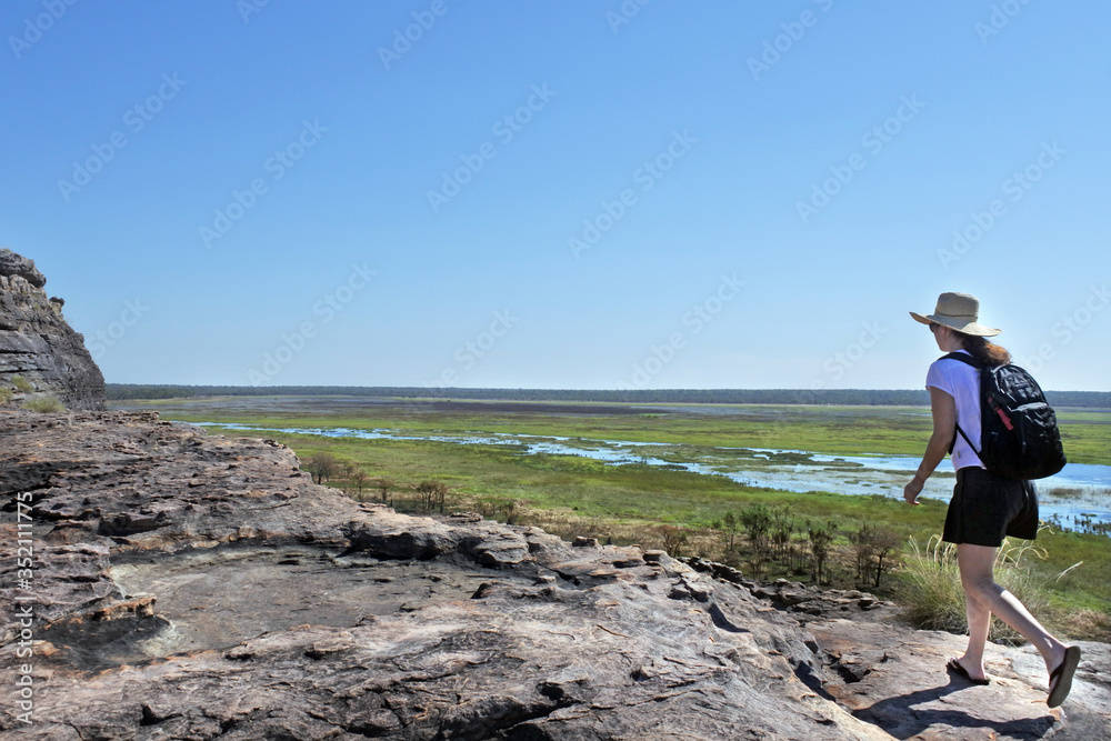 Woman tourist hiking at Ubirr rock art site in Kakadu National P