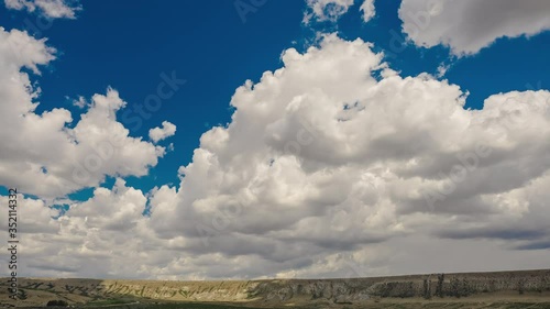 Aerial view of the Klementyev mountain in Koktebel under dense beautiful clouds in sunny weather. Ideal place for paragliding in Crimea. Stunning panoramic shot of the mountain in timelapse. photo
