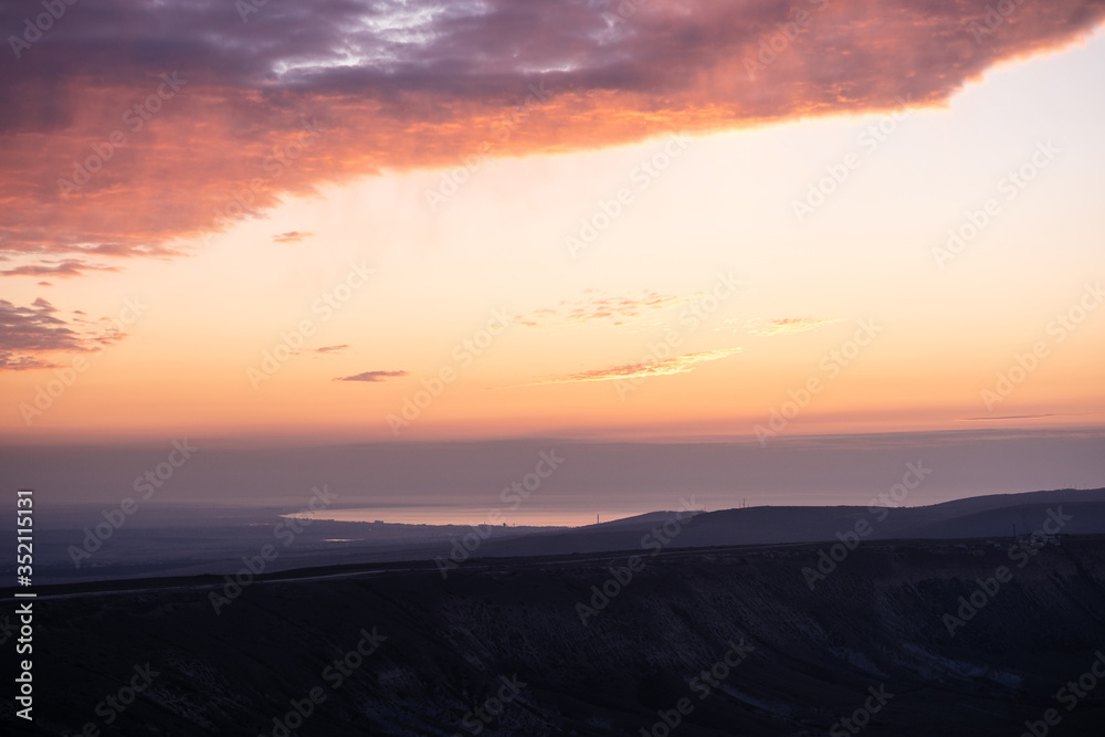 Beautiful orange sky. Sunset over the sea and mountains. No people. Panoramic photography.