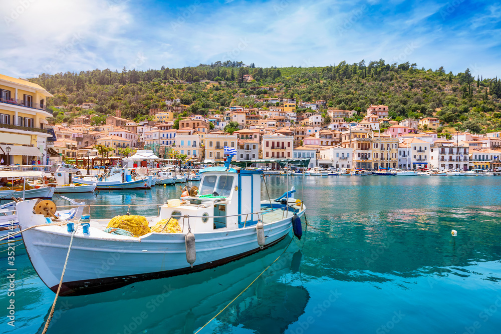 Der idyllische Hafen von Gytheio auf dem Peloponnes in Griechenland mit Fischerbooten, smaragdgrünem Meer und Sonnenschein