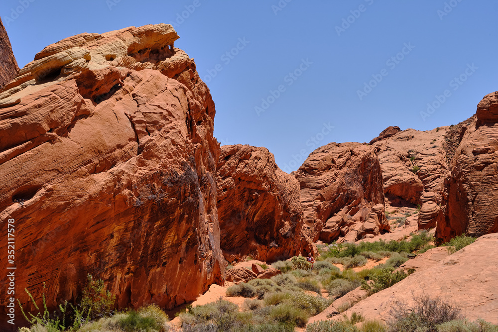 Rocks and cliffs of Red Aztec Sandstone line the Nevada desert