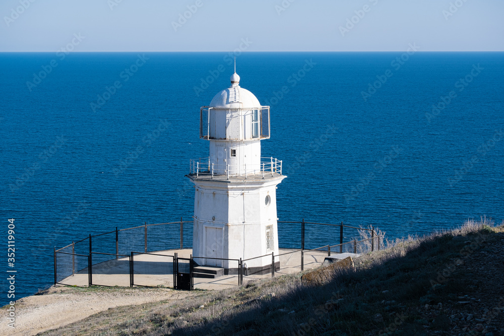 White lighthouse against the blue sea. White lighthouse against the blue sea.