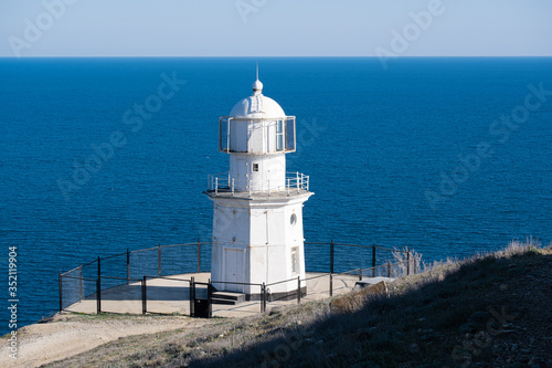 White lighthouse against the blue sea.