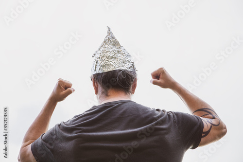 Man with a tin foil hat on his head demonstrate angry, concept conspiracy theory and schwurbler photo