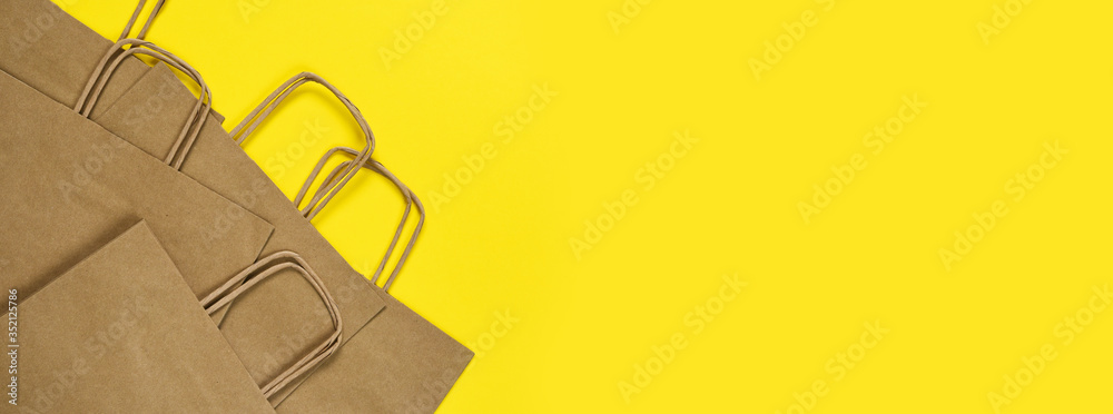 Set of craft paper bags for shopping on a yellow background.Flatly.Gift bag.