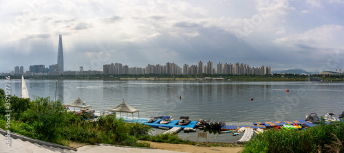 Panorama view of skyscraper with Lotte world tower and Seoul Olympic stadium, view across the boats pier in the Han river. photo