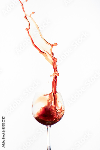 Splash red water in a wine glass with white background