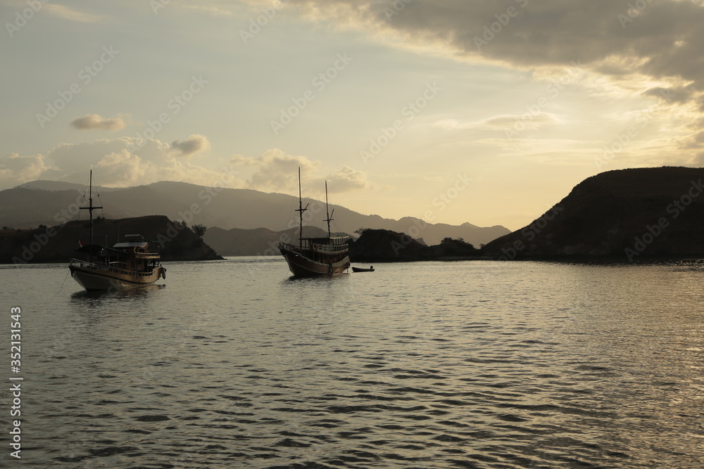 Fototapeta premium Two ship sailing together at sunset in the sea of Bali