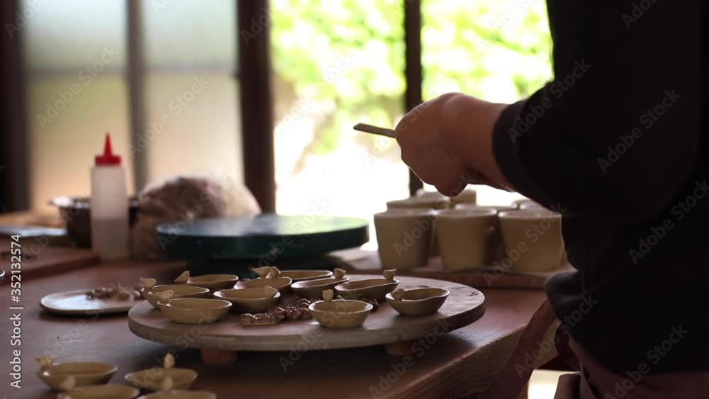 Female potter sands her works. Female potter sands her works.