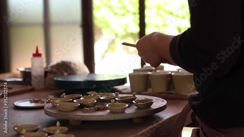 Female potter sands her works.