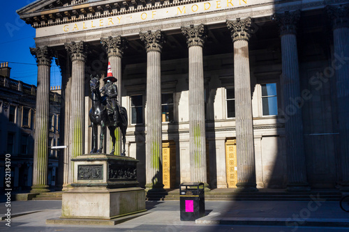 The Duke of Wellington Sculpture in Glasgow city centre with a cone on his head and a personal protective equipment face mask on his face during the 2020 Corona Virus lockdown in Scotland.  