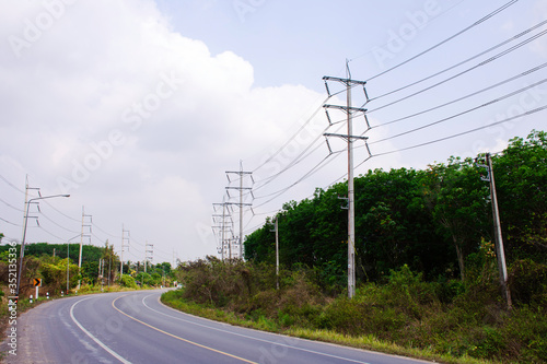 Transmission line of electricity to rural with green tree, High voltage electricity pole with nature background