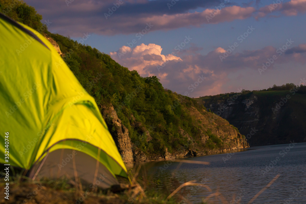 Obraz premium camping at fjords. Lonely green tent pitched near lake