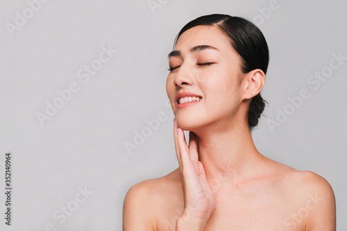 Face of Young beautiful asian woman with clean, fresh and bright skin, Happiness and cheerful with positive emotional,isolated on gray background,Beauty Cosmetics and Facial treatment Concept
