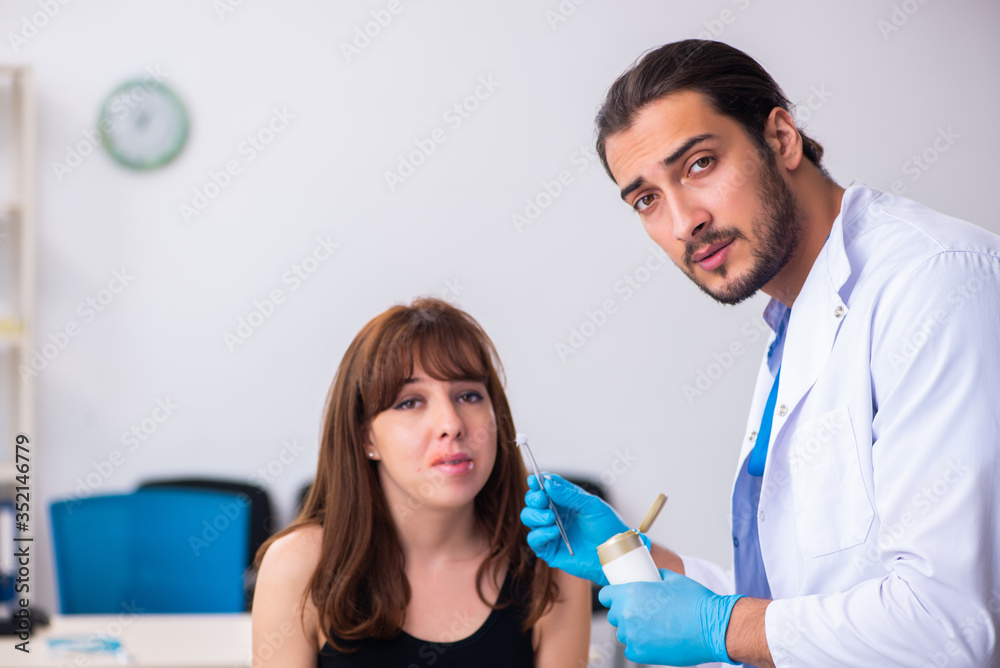 Fototapeta premium Young woman visiting male doctor dermatologist