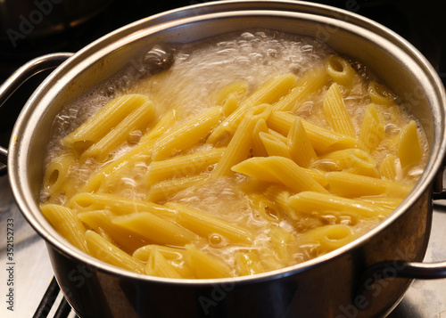 Konstfotografi pasta while cooking in the boiling water of the pot in the kitch