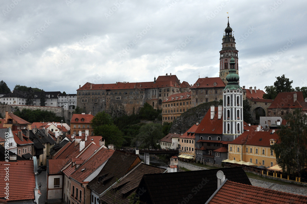 Panorama of the high walls of the castle, tower and church of St. Vitus in the historic city of Cesky Krumlov. View from the seminary park.