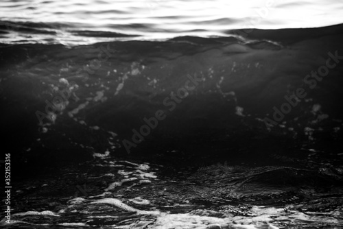 Monochrome waves of water on a pebble beach