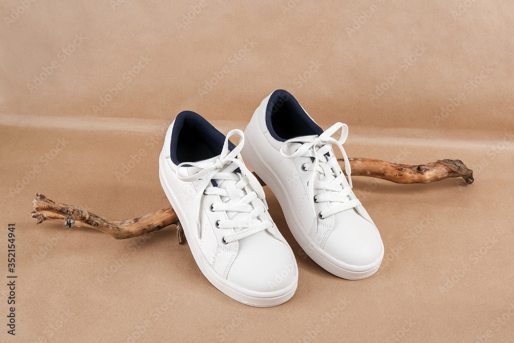 Ethical vegan shoes concept. A pair of white sneakers on the wooden snag,  neutral beige craft paper background. Minimal style Stock Photo | Adobe  Stock