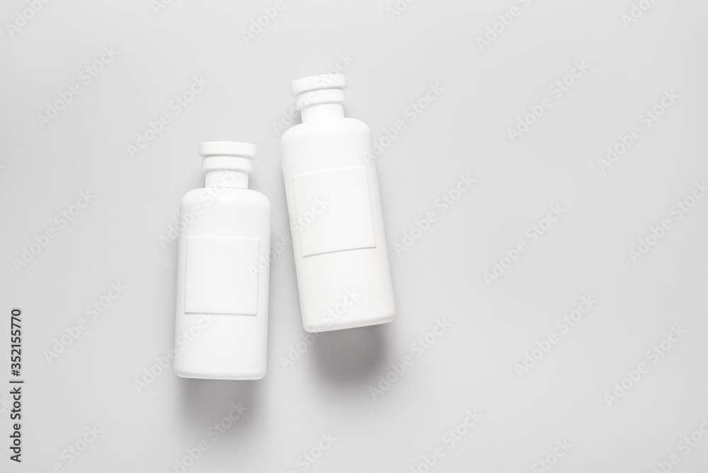 Set of plastic shampoo, cosmetics bottles on grey background Set of plastic shampoo, cosmetics bottles on grey background